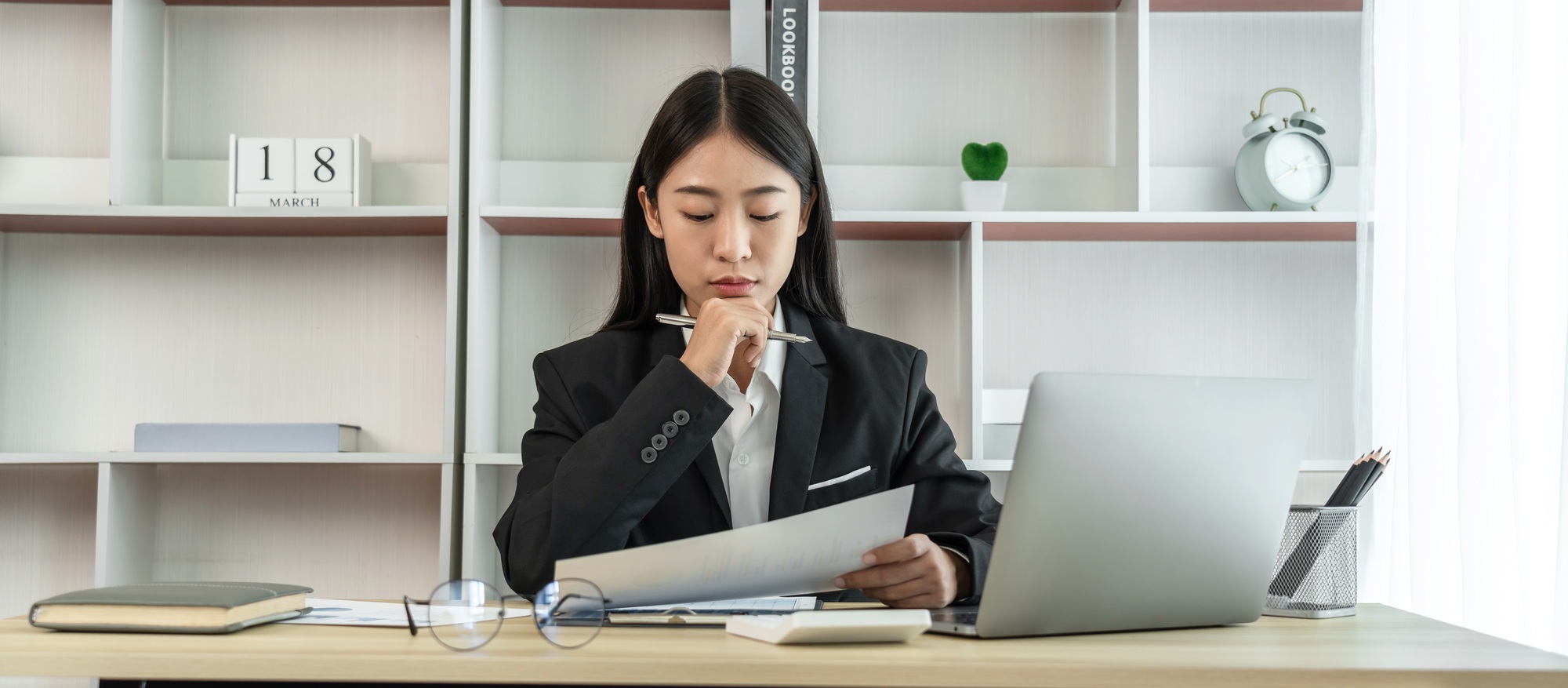 Asian business women are analyzing company sales statistical graphs to develop them further