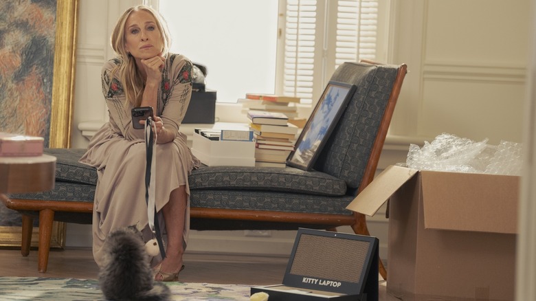 Carrie thinking in her living room with her cat at her feet in ...And Just Like That