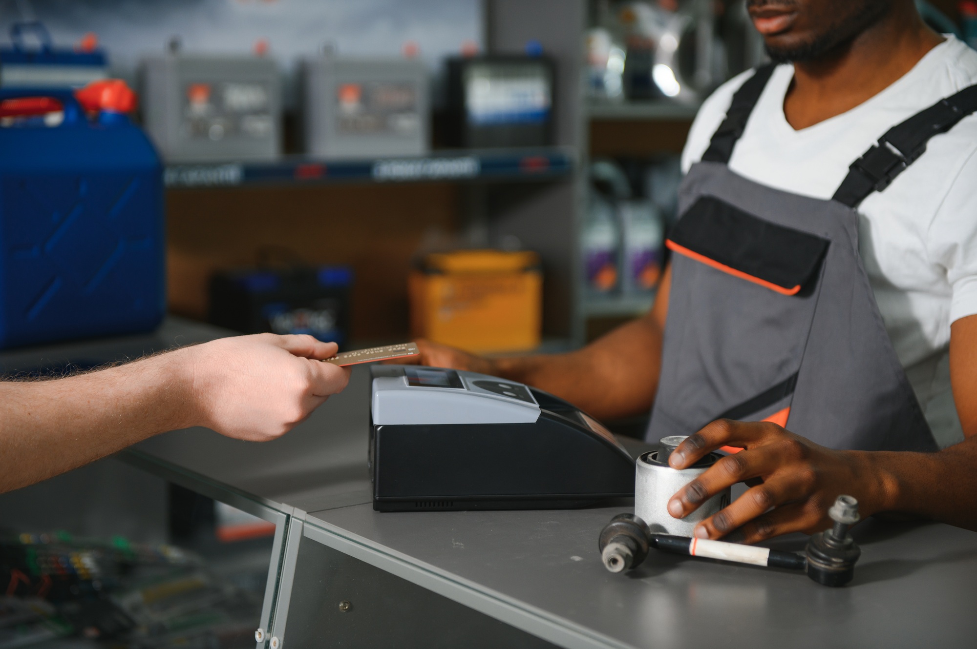 Close up. The buyer pays for the purchase of auto parts through a POS terminal