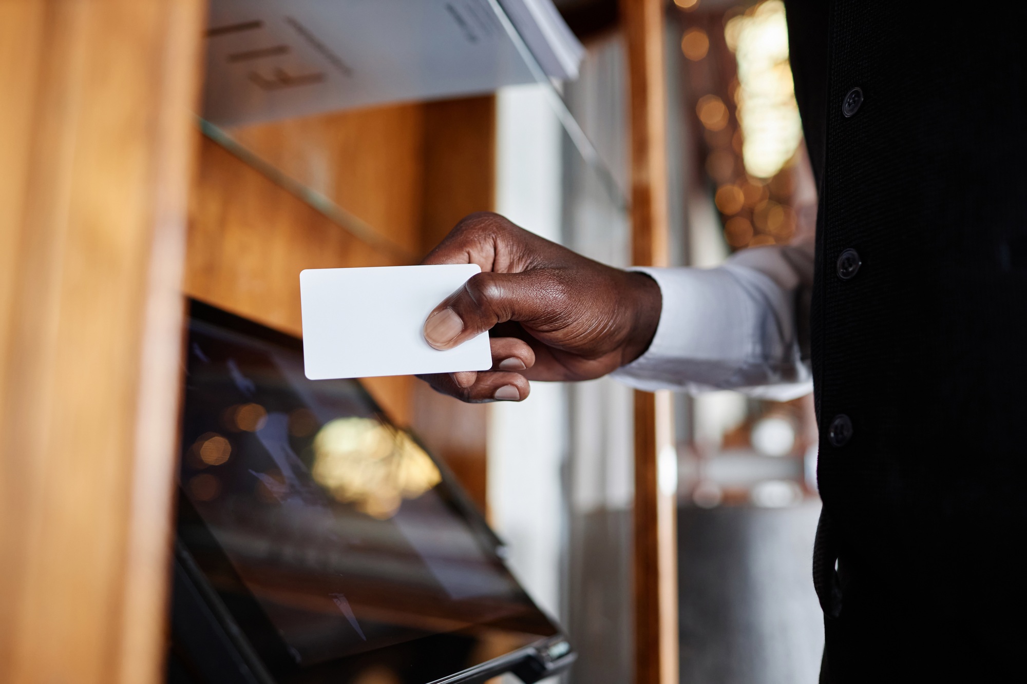 Male waiter swiping card and using computer in restaurant POS system