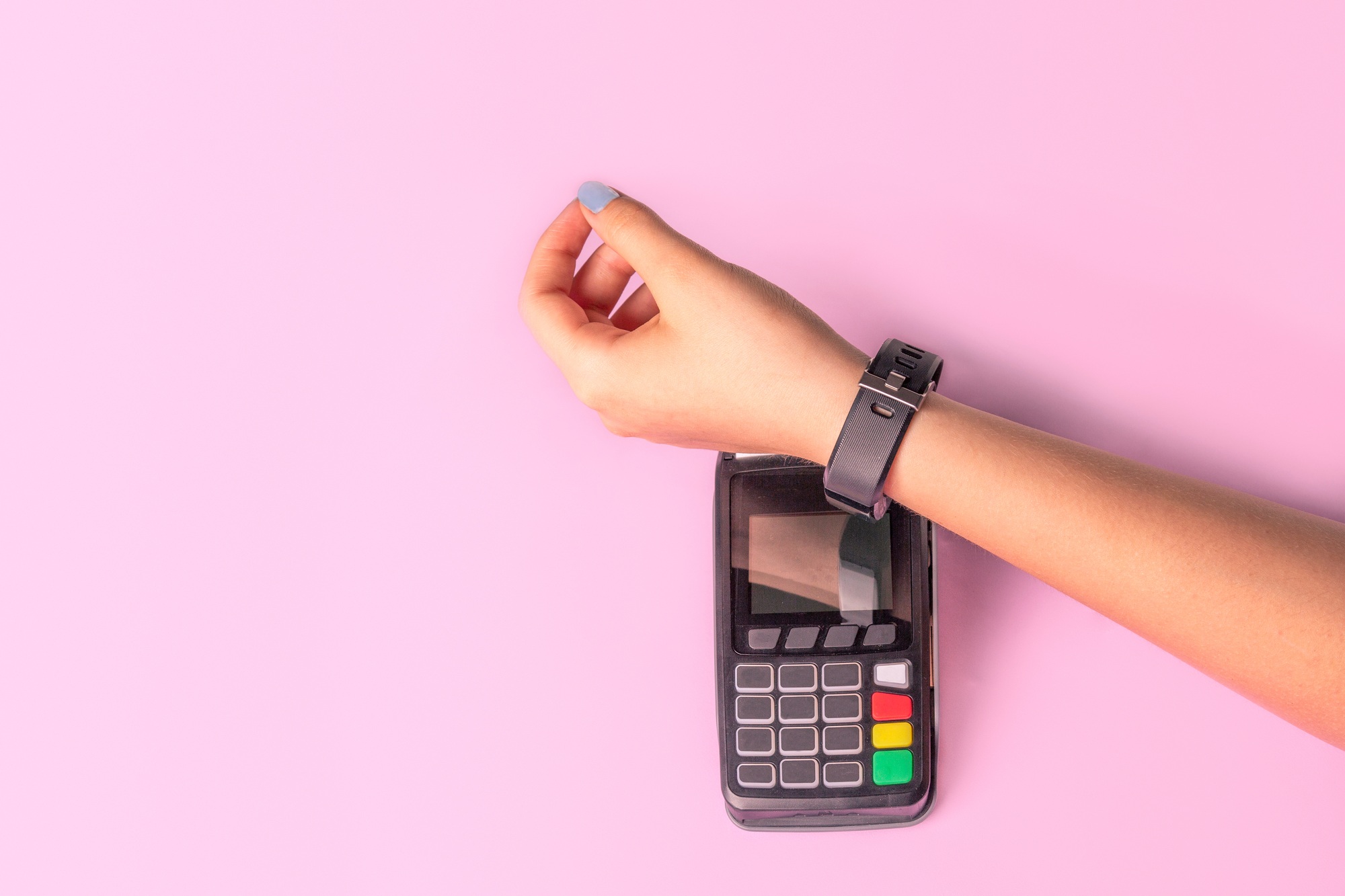 Payment for purchases using smart watches and POS terminal on light pink background.