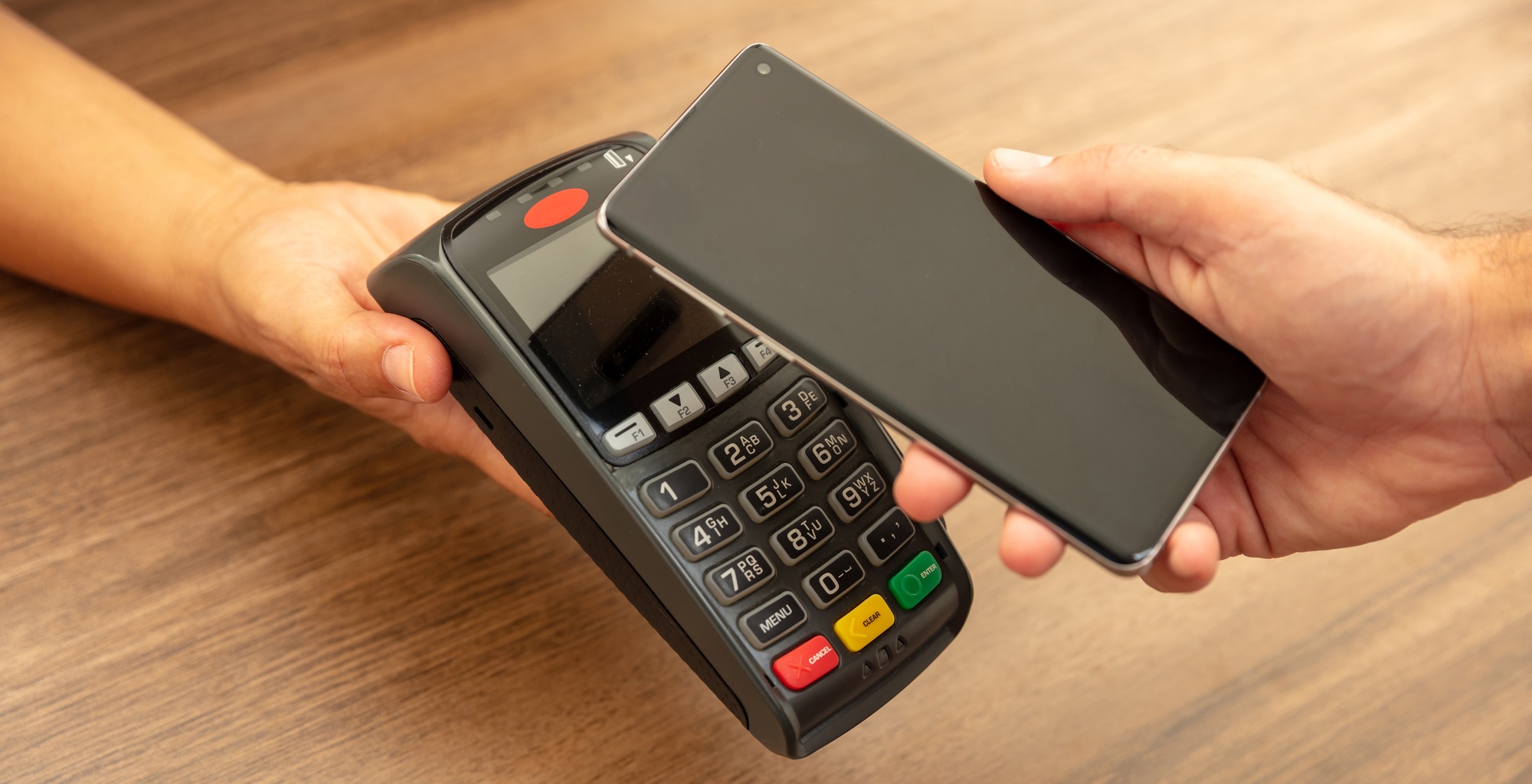 POS terminal for payment with smartphone, nfc technology. Cashier and customer hands