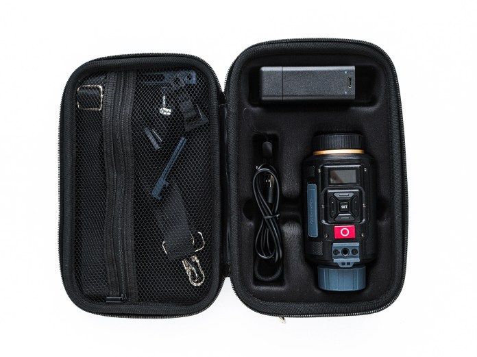 Open case containing the AKASO Sight-300 digital monocular, a battery, and various accessories.