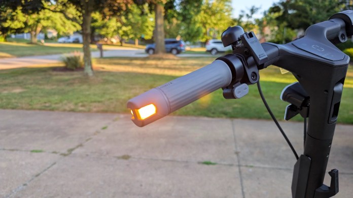 Close-up of the Navee ST3 Pro scooter's handlebar featuring an illuminated LED light, showcasing its design and functionality.