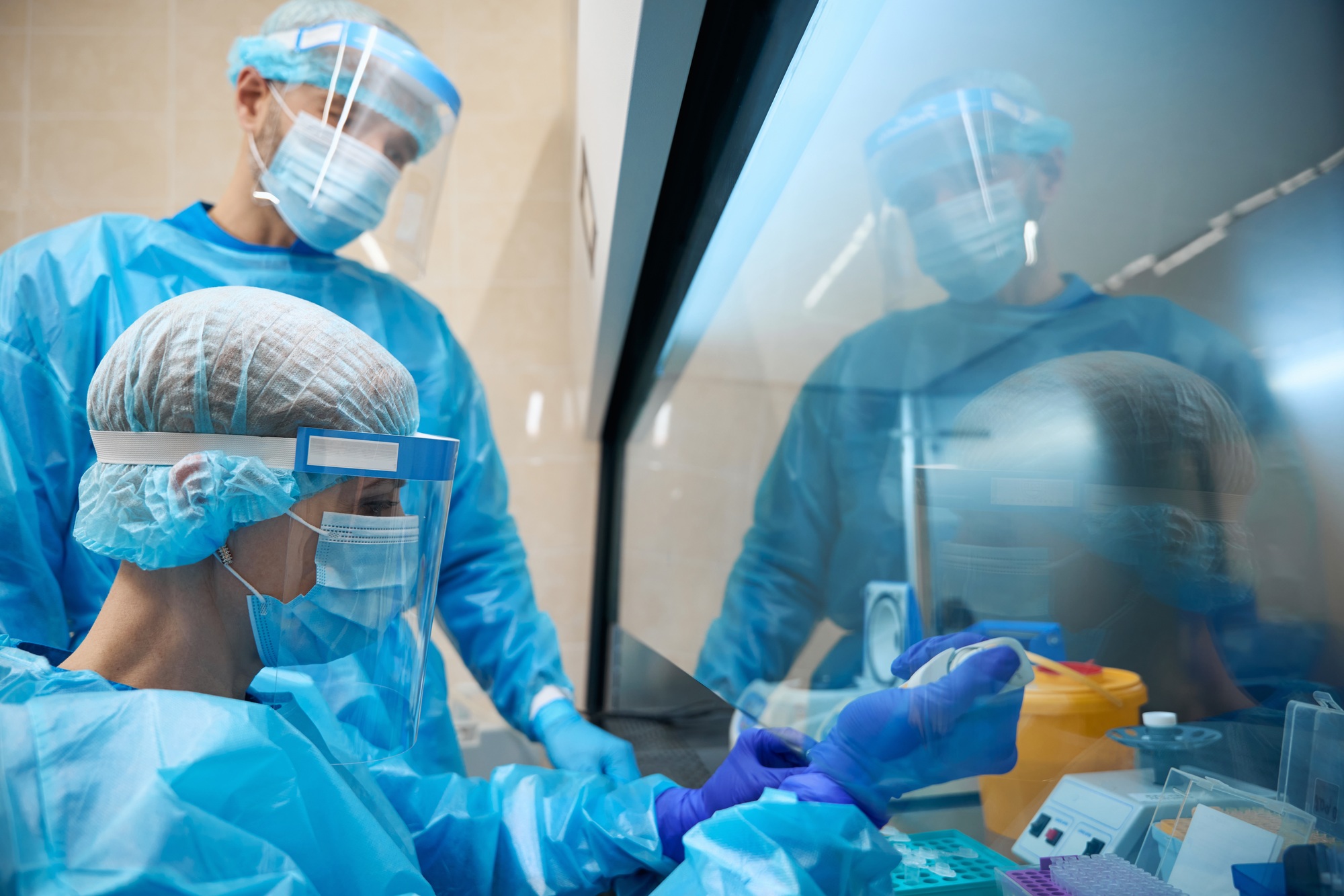 Laboratory staff work with biomaterial in compliance with safety precautions