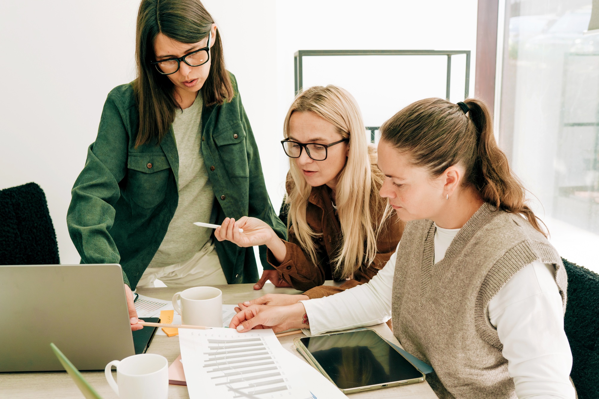 Modern business women working in the office discuss schedules and strategy development programs.