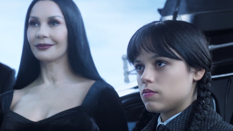 Morticia smiles while Wednesday sulks in Season 1 of Wednesday